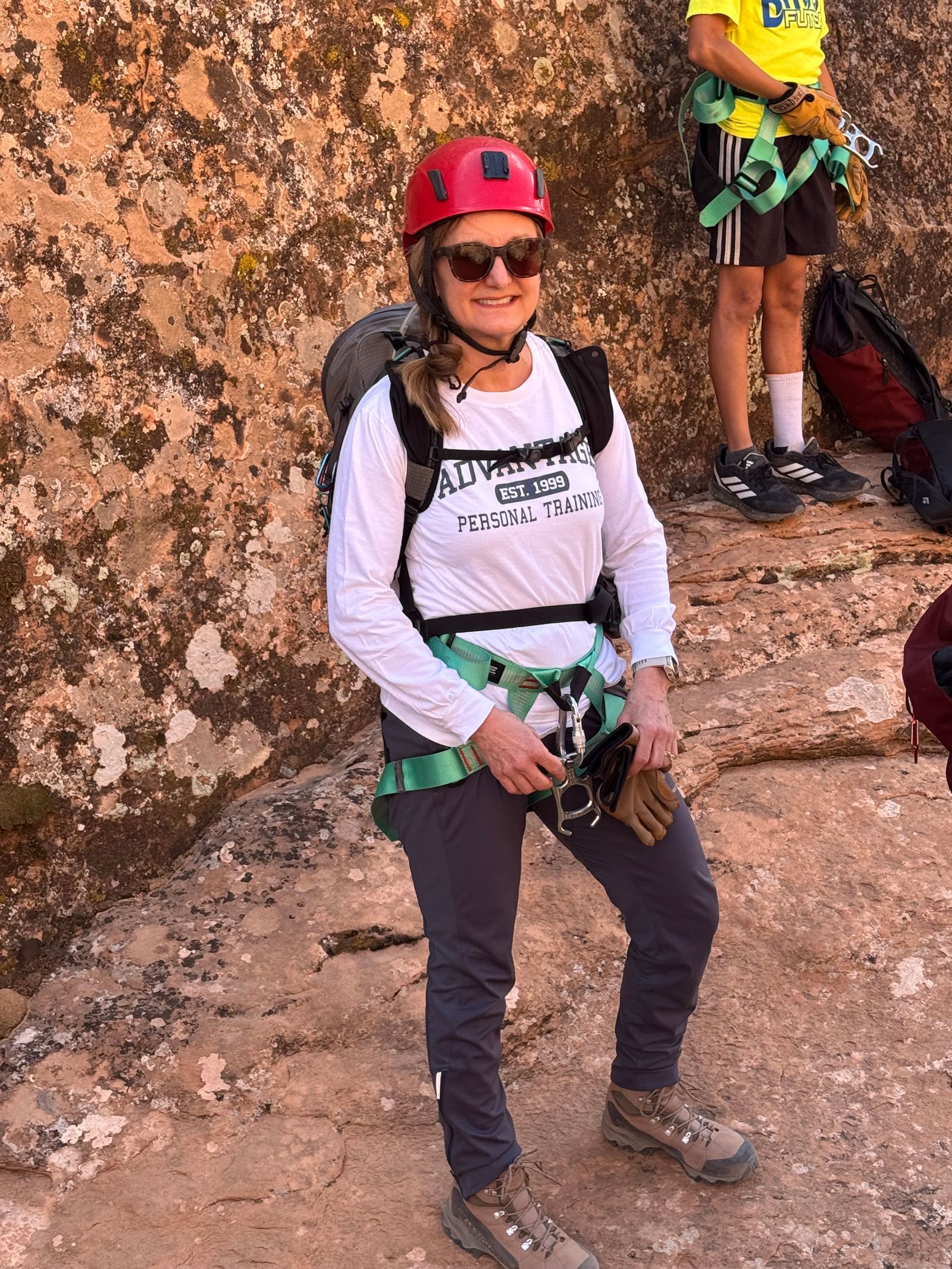 Jodi rock climbing in a helmet and an Advantage long-sleeve shirt
