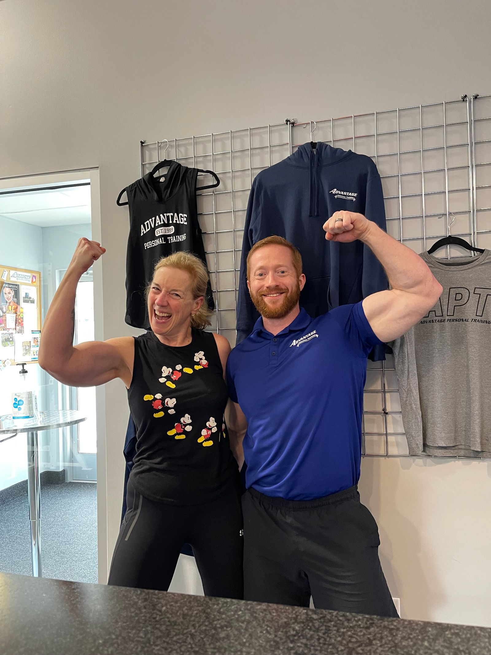 Maddie flexing beside a coach in a blue Advantage polo